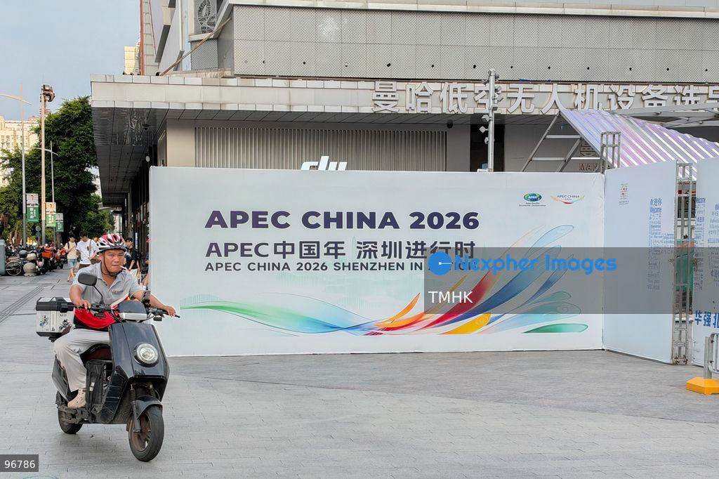 Pedestrians walk past construction hoardings promoting the upcoming APEC 2026 summit surrounding an outdoor public renovation site in the Huaqiangbei commercial electronics hub on September 22, 2026 in Shenzhen, Guangdong Province, China. The city is upgrading pedestrian zones and public infrastructure ahead of hosting the international economic forum. (Photo by Kevin Li/TMHK via Nexpher Images)