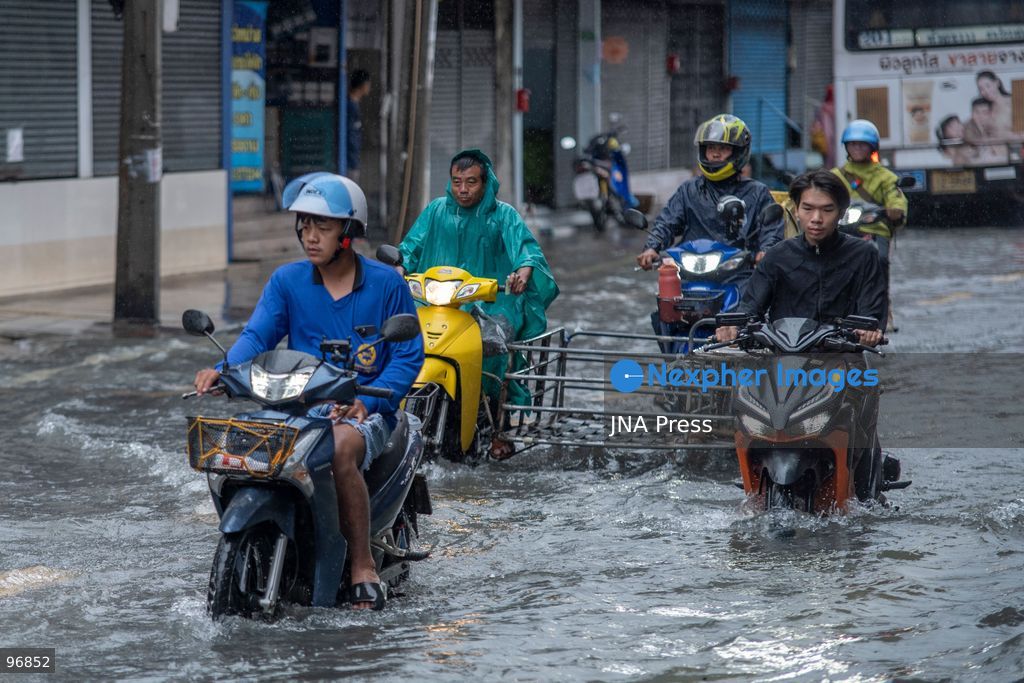 BANGKOK, THAILAND, SEPTEMBER 26, 2026: People and vehicles make their way through flooded streets following heavy rainfall in Bangkok. Thailand has experienced widespread rain as a monsoon trough and low-pressure system affect Bangkok, the Central region and other parts of the country, increasing the risk of flash floods and urban flooding. Photo by Panawat Seangsotg / JNA Press. (Photo by Panawat Seangsotg/JNA Press via Nexpher Images)