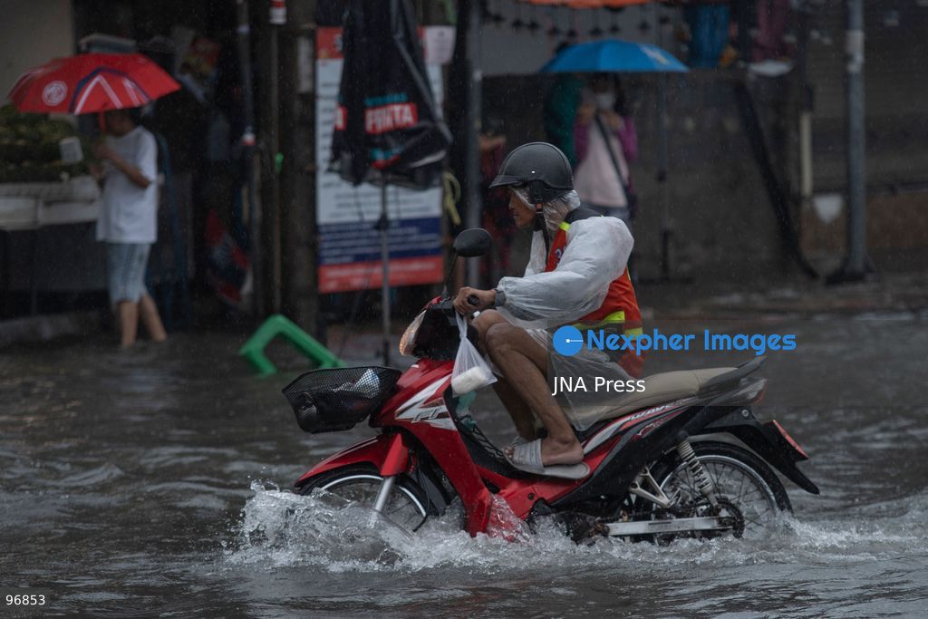 BANGKOK, THAILAND, SEPTEMBER 26, 2026: People and vehicles make their way through flooded streets following heavy rainfall in Bangkok. Thailand has experienced widespread rain as a monsoon trough and low-pressure system affect Bangkok, the Central region and other parts of the country, increasing the risk of flash floods and urban flooding. Photo by Panawat Seangsotg / JNA Press. (Photo by Panawat Seangsotg/JNA Press via Nexpher Images)