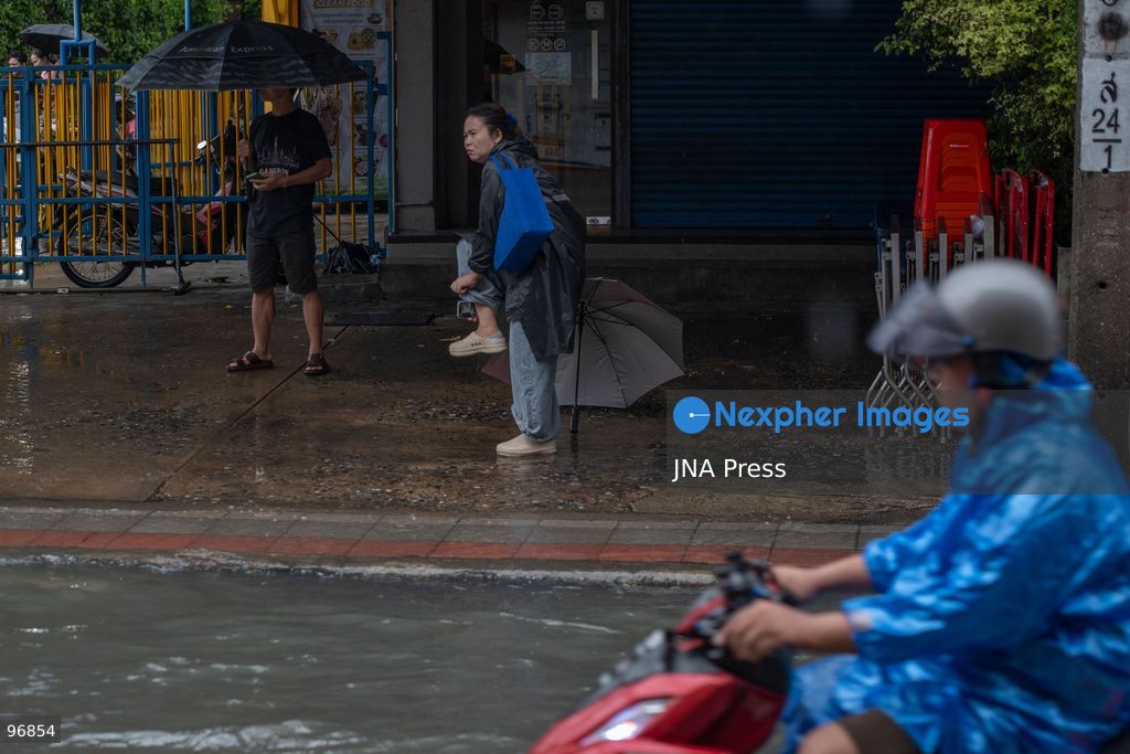 BANGKOK, THAILAND, SEPTEMBER 26, 2026: People and vehicles make their way through flooded streets following heavy rainfall in Bangkok. Thailand has experienced widespread rain as a monsoon trough and low-pressure system affect Bangkok, the Central region and other parts of the country, increasing the risk of flash floods and urban flooding. Photo by Panawat Seangsotg / JNA Press. (Photo by Panawat Seangsotg/JNA Press via Nexpher Images)
