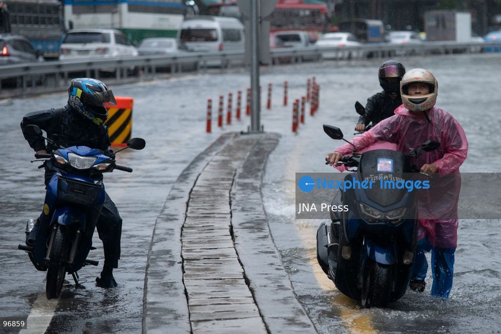 BANGKOK, THAILAND, SEPTEMBER 26, 2026: People and vehicles make their way through flooded streets following heavy rainfall in Bangkok. Thailand has experienced widespread rain as a monsoon trough and low-pressure system affect Bangkok, the Central region and other parts of the country, increasing the risk of flash floods and urban flooding. Photo by Panawat Seangsotg / JNA Press. (Photo by Panawat Seangsotg/JNA Press via Nexpher Images)