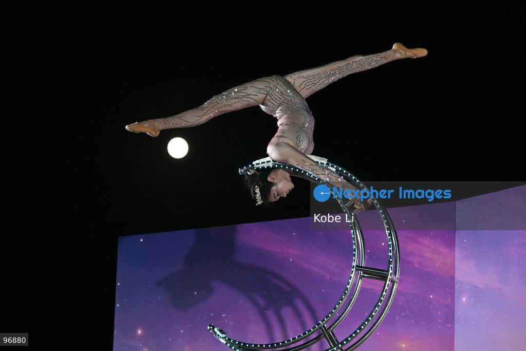A performer executes a tumbling routine on a circular apparatus during a nighttime event and a moon is visible in the sky in Hung Hom New Waterfront the day after the Mid-Autumn Festival on September 26, 2026 in Hong Kong. (Photo by Kobe Li/Nexpher Images)