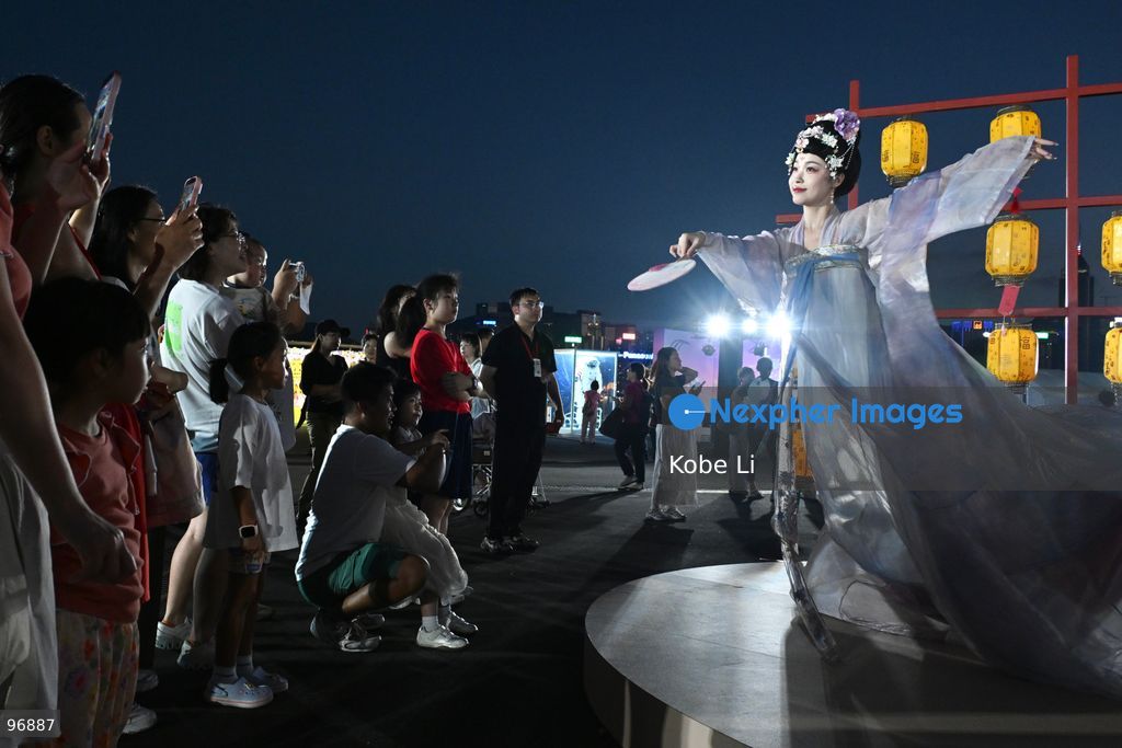 Visitors watch as a performer in traditional Hanfu attire performs in Hung Hom New Waterfront the day after the Mid-Autumn Festival on September 26, 2026 in Hong Kong. (Photo by Kobe Li/Nexpher Images)