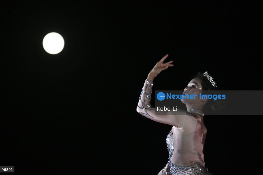 A performer executes a tumbling routine on a circular apparatus during a nighttime event and a moon is visible in the sky in Hung Hom New Waterfront the day after the Mid-Autumn Festival on September 26, 2026 in Hong Kong. (Photo by Kobe Li/Nexpher Images)