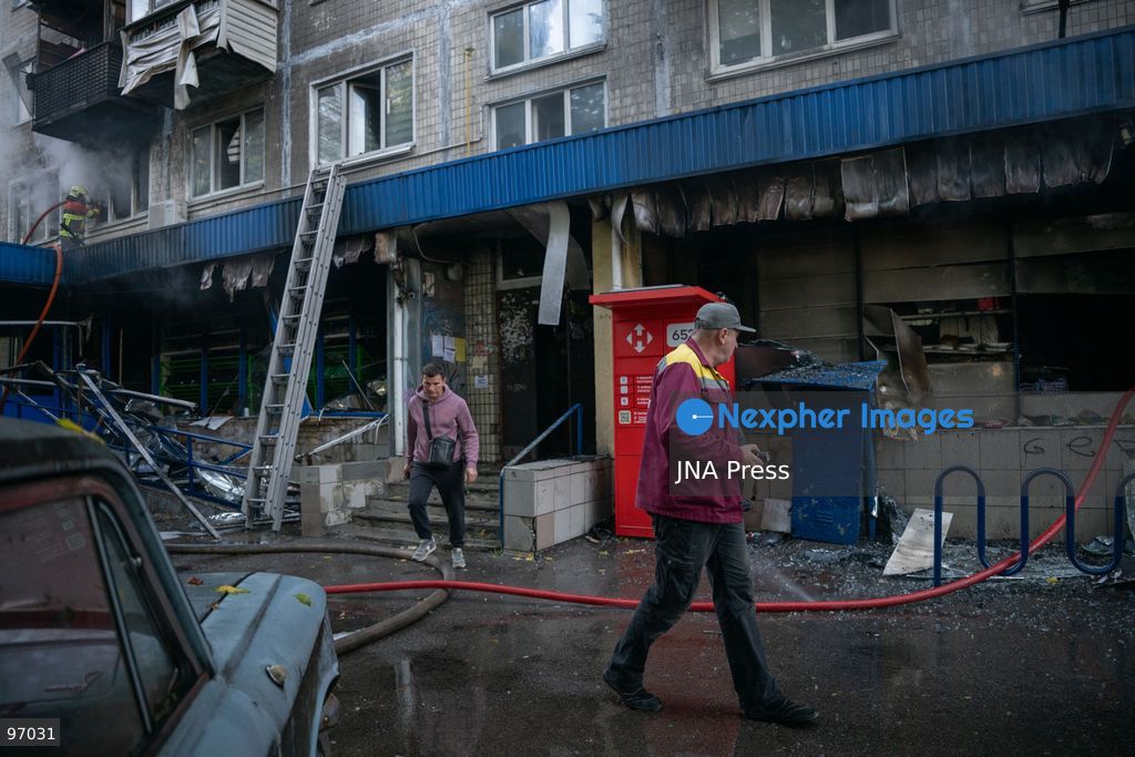 KYIV, UKRAINE, SEPTEMBER 26, 2026: Firefighters work at a five-story residential building damaged during a Russian drone attack in Kyiv’s Solomianskyi district, as residents watch emergency operations and clear shattered glass from the area. Kyiv authorities said a fire broke out at the residential building and a ground-floor shop following the fall of a drone, injuring four people and prompting rescuers to evacuate 20 residents. Photo by Nastasssia Torres / JNA Press. (Photo by Nastassia Kantorowicz Torres/JNA Press via Nexpher Images)