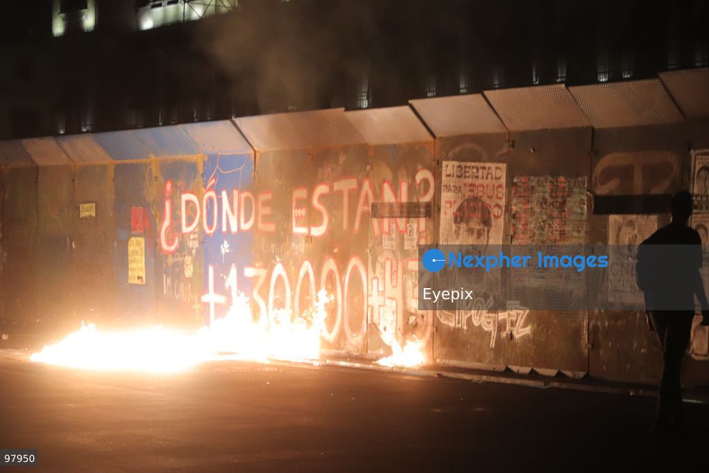 Fire burns on the ground next to a protective fence outside National Palace during a rally to demand justice and truth on the 12th anniversary of the disappearance of the 43 students, in Mexico City, Mexico on September 26, 2026. (Photo by Carlos Santiago/ Eyepix Group) (Photo by Carlos Santiago/ Eyepix Group/Eyepix via Nexpher Images)