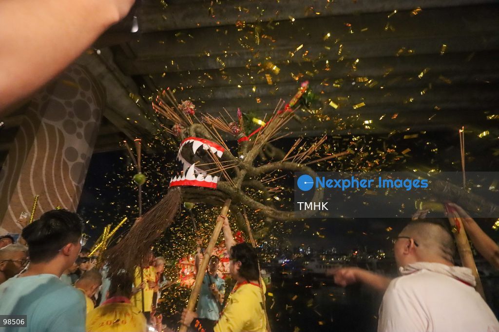 A general view shows participants and performers lowering the incense-adorned fire dragon into the waters of Causeway Bay Typhoon Shelter during the "Dragon Returning to the Sea" ritual on September 26, 2026 in Hong Kong. Held on the 16th day of the eighth lunar month to mark the Chasing the Moon festival, the sacred ceremony concluded the 147th anniversary of the national intangible cultural heritage tradition, symbolising the cleansing of misfortune and bringing peace to the community before the dragon was retrieved in accordance with modern environmental practices. (Photo by Gordon Choi/TMHK via Nexpher Images)