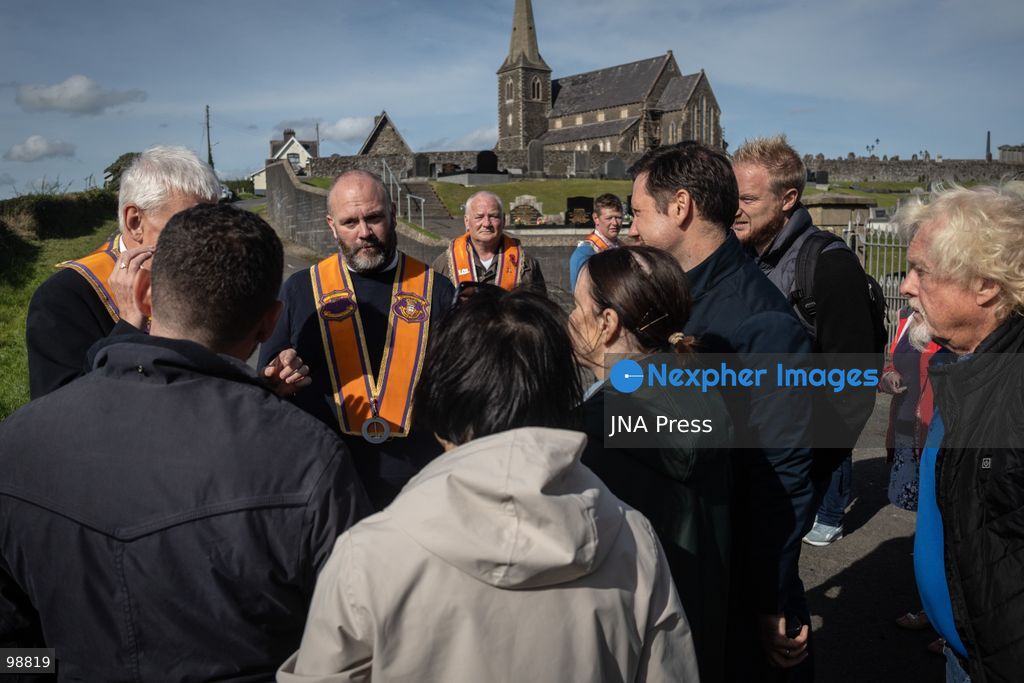 PORTADOWN, NORTHERN IRELAND, SEPTEMBER 28, 2026: Members of the Orange Order gather near Drumcree Parish Church as a standoff over the contentious Drumcree parade continues in Portadown. The Protestant fraternal organization had been granted conditional permission to march along the predominantly nationalist Garvaghy Road for the first time in nearly three decades, but the route was blocked by thousands of protesters and police prevented the parade from proceeding amid public safety concerns. On Monday, residents continued gathering on Garvaghy Road while Orange Order members remained near Drumcree Church as discussions continued with police and officials over the dispute. Photo by Nadia Caimi / JNA Press. (Photo by Nadia Caimi/JNA Press via Nexpher Images)