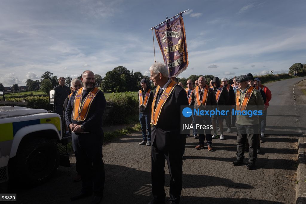 PORTADOWN, NORTHERN IRELAND, SEPTEMBER 28, 2026: Members of the Orange Order gather near Drumcree Parish Church as a standoff over the contentious Drumcree parade continues in Portadown. The Protestant fraternal organization had been granted conditional permission to march along the predominantly nationalist Garvaghy Road for the first time in nearly three decades, but the route was blocked by thousands of protesters and police prevented the parade from proceeding amid public safety concerns. On Monday, residents continued gathering on Garvaghy Road while Orange Order members remained near Drumcree Church as discussions continued with police and officials over the dispute. Photo by Nadia Caimi / JNA Press. (Photo by Nadia Caimi/JNA Press via Nexpher Images)