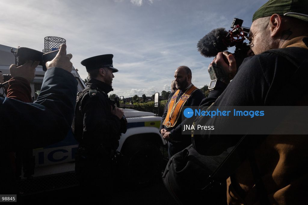 PORTADOWN, NORTHERN IRELAND, SEPTEMBER 28, 2026: Members of the Orange Order gather near Drumcree Parish Church as a standoff over the contentious Drumcree parade continues in Portadown. The Protestant fraternal organization had been granted conditional permission to march along the predominantly nationalist Garvaghy Road for the first time in nearly three decades, but the route was blocked by thousands of protesters and police prevented the parade from proceeding amid public safety concerns. On Monday, residents continued gathering on Garvaghy Road while Orange Order members remained near Drumcree Church as discussions continued with police and officials over the dispute. Photo by Nadia Caimi / JNA Press. (Photo by Nadia Caimi/JNA Press via Nexpher Images)