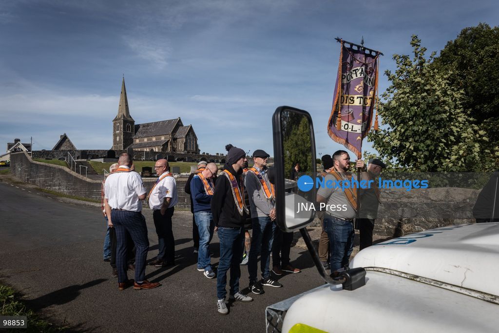 PORTADOWN, NORTHERN IRELAND, SEPTEMBER 28, 2026: Members of the Orange Order gather near Drumcree Parish Church as a standoff over the contentious Drumcree parade continues in Portadown. The Protestant fraternal organization had been granted conditional permission to march along the predominantly nationalist Garvaghy Road for the first time in nearly three decades, but the route was blocked by thousands of protesters and police prevented the parade from proceeding amid public safety concerns. On Monday, residents continued gathering on Garvaghy Road while Orange Order members remained near Drumcree Church as discussions continued with police and officials over the dispute. Photo by Nadia Caimi / JNA Press. (Photo by Nadia Caimi/JNA Press via Nexpher Images)