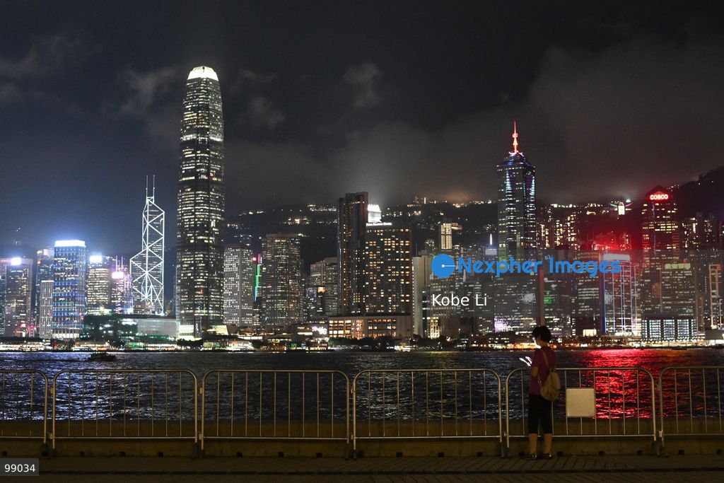 A person looks out at the illuminated skyline of Hong Kong at night, standing near a railing on September 29, 2026 in Hong Kong. (Photo by Kobe Li/Nexpher Images)