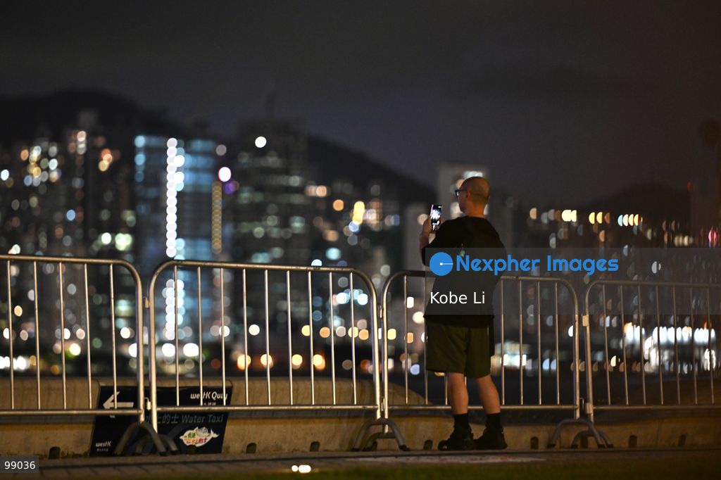 A person stands near a railing, looking out at the illuminated skyline of Hong Kong at night on September 29, 2026 in Hong Kong. (Photo by Kobe Li/Nexpher Images)