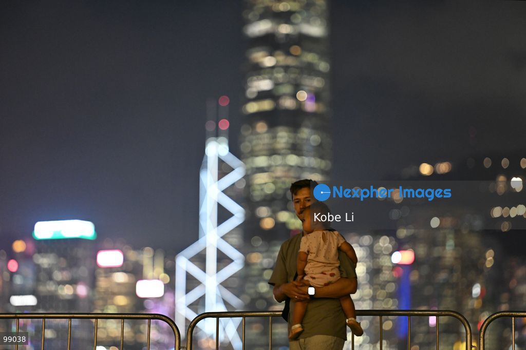 A man holds his child while looking out at the illuminated skyline of Hong Kong at night on September 29, 2026 in Hong Kong. (Photo by Kobe Li/Nexpher Images)