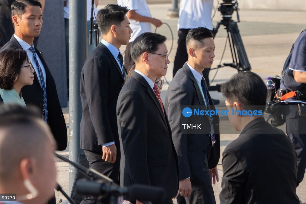 Hong Kong Chief Executive John Lee Ka-chiu and his wife, Janet Lam Lai-sim, greet and chat with members of youth uniformed groups before proceeding to the designated viewing area for the National Day flag-raising ceremony at Golden Bauhinia Square on October 1, 2026 in Hong Kong. (Photo by Kevin Li/TMHK via Nexpher Images)
