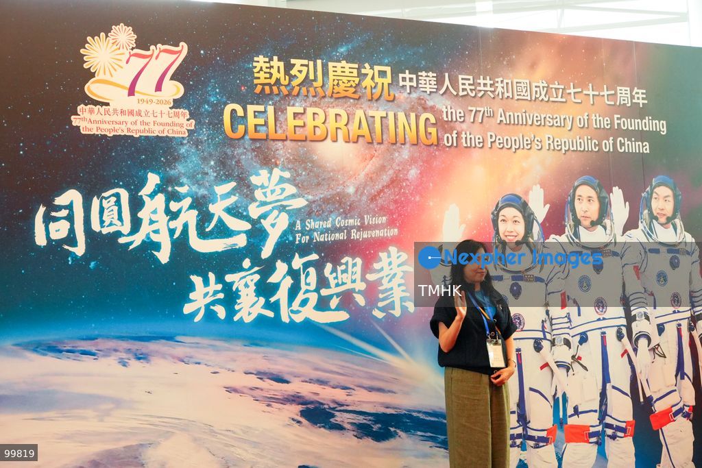 Attendees pose for photos in front of aerospace displays and space mission panels set up outside the Grand Hall of the Hong Kong Convention and Exhibition Centre ahead of the 77th National Day reception on October 1, 2026 in Hong Kong. (Photo by Zulu Lo/TMHK via Nexpher Images)