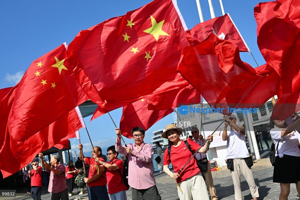 People holding a national flag of China and regional flag of Hong Kong on October 1, 2026 in Hong Kong. Today is the China's National Day. (Photo by STR/Nexpher Images)