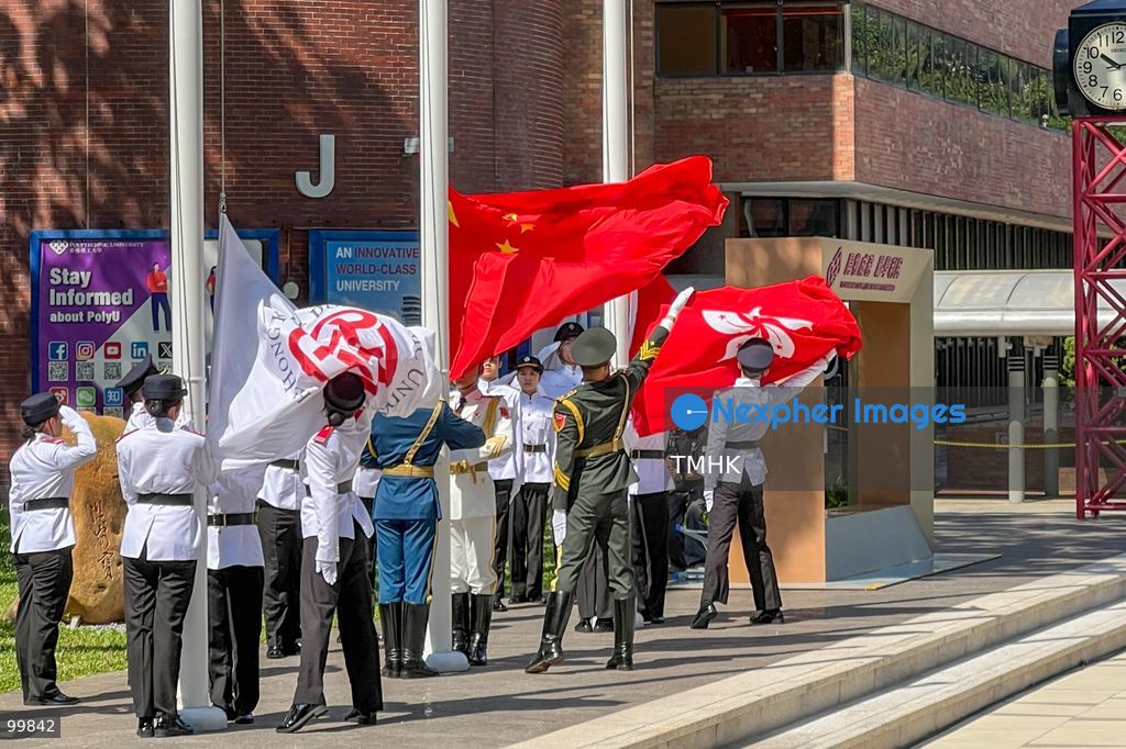 A flag bearer from the guard of honour of the Chinese People's Liberation Army (PLA) Hong Kong Garrison and members of the PolyU Student Flag-Raising Team fling and unfurl the national flag of China as it is raised during the 77th National Day flag-raising ceremony at The Hong Kong Polytechnic University on October 1, 2026 in Hong Kong. (Photo by Peter Tsang/TMHK via Nexpher Images)