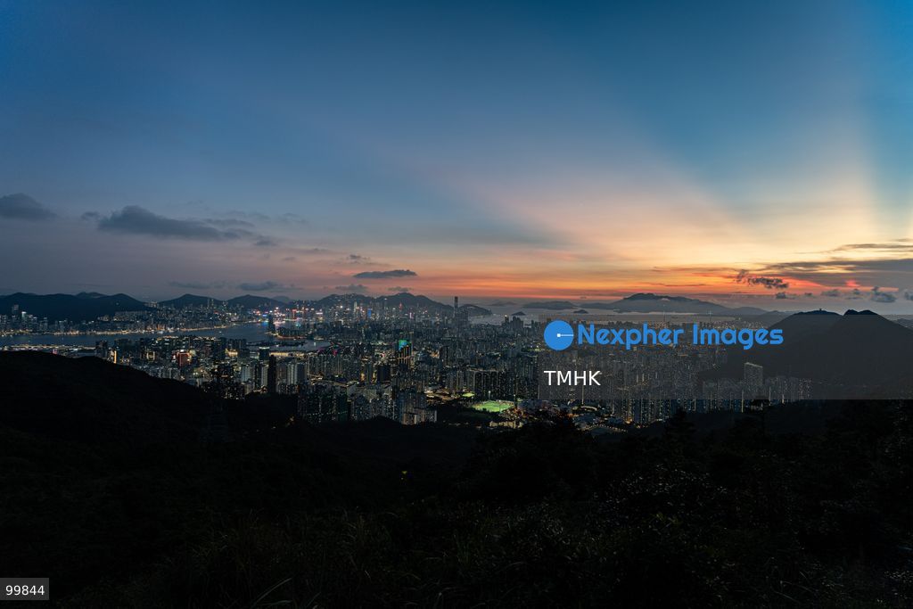 A panoramic general view captured from Kowloon Peak (Fei Ngo Shan) shows the sun setting over the Kowloon Peninsula and Victoria Harbour ahead of the National Day evening celebrations on October 1, 2026 in Hong Kong, casting a golden glow across the urban cityscape and harbour skyline. (Photo by Kevin Li/TMHK via Nexpher Images)