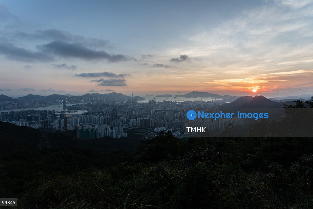 A panoramic general view captured from Kowloon Peak (Fei Ngo Shan) shows the sun setting over the Kowloon Peninsula and Victoria Harbour ahead of the National Day evening celebrations on October 1, 2026 in Hong Kong, casting a golden glow across the urban cityscape and harbour skyline. (Photo by Kevin Li/TMHK via Nexpher Images)